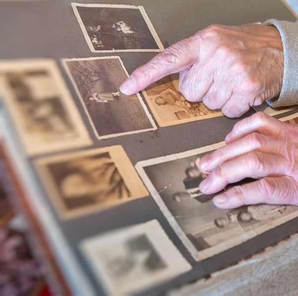 hands pointing at a photo in a family album