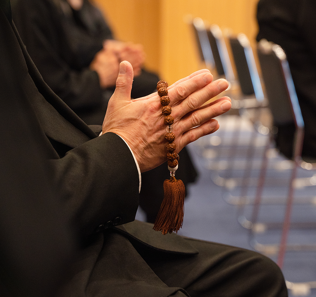 praying hands holding a rosary