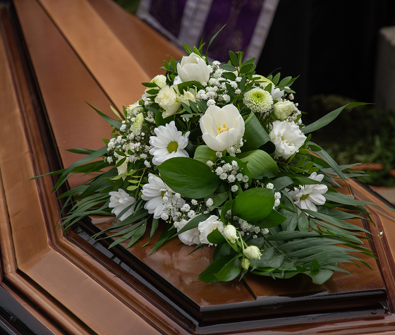 flower arrangement on top of coffin