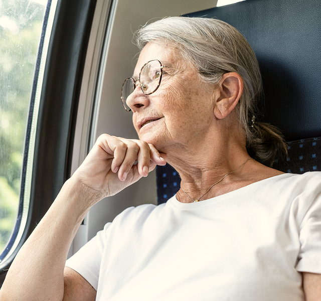 elderly woman looking out a window